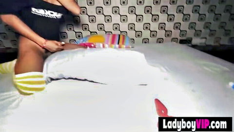 Gorgeous Thai ladyboy in crop top and striped socks spreads legs teasing tight ass