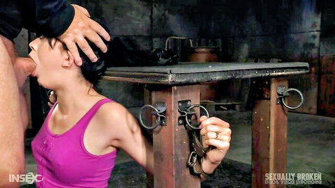 Skinny brunette slave gags on thick cock deepthroated by dominant man in metal bondage frame