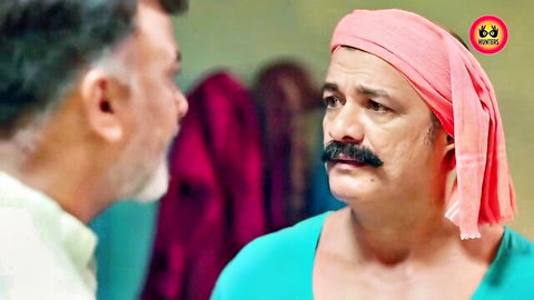 Two mature Indian men with mustaches talking closely in colorful attire