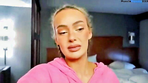 Blonde vlogger in pink hoodie, casual bedroom vlog style