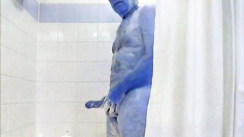 Nude older muscular man in blue body paint showering, hand on cock