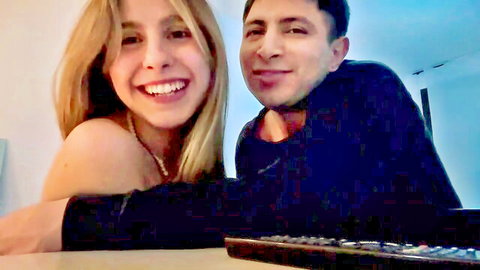 Smiling blonde babe with bare shoulders cuddling handsome guy on webcam selfie