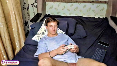 Twink gamer boy with small soft cock exposed plays Xbox naked on bed solo