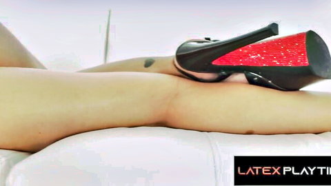 Crystal Rush seductive leg pose in black latex heels with red soles