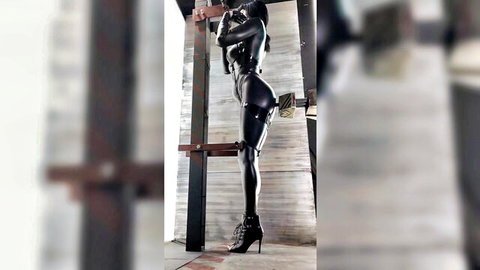 Lara in shiny black latex catsuit, seductive over-shoulder pose