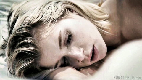 Blonde short-haired babe lying in ecstasy with parted lips and closed eyes