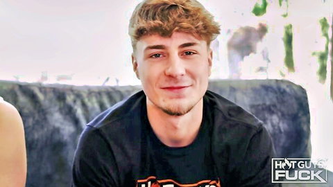 Smiling muscular guy with curly red hair in black shirt, adult video thumbnail