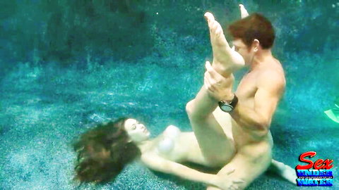 Muscular nude man grips raised legs of wet nude Asian babe for underwater fucking