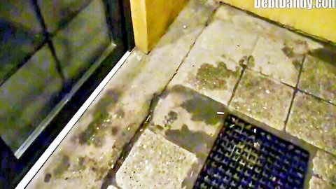 Blurry low-angle view of tiled outdoor patio with door and water stains