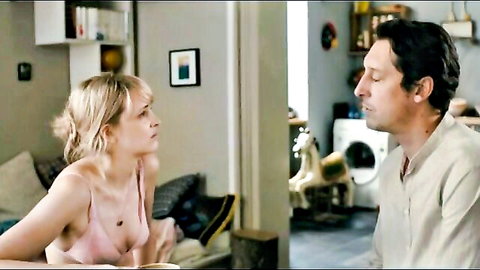 Blonde with medium tits in revealing pink tank top leans forward in sensual conversation with dark-haired man in living room