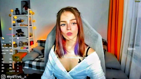 Pink-haired e-girl teen pouts lips on webcam, deep cleavage spilling from loose white top