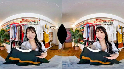 Cute Asian babe in VR holding black green dress in wardrobe room smiling