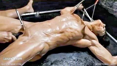 Abby stretched naked on frame with genital clamps in Queensnake BDSM