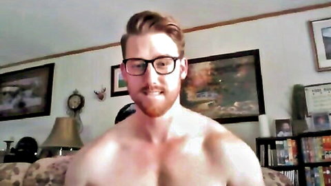Muscular redhead with glasses and beard flexes shirtless torso on webcam