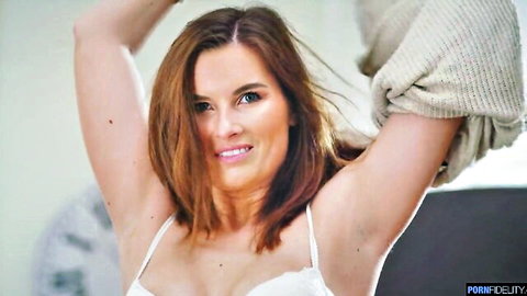 Jennifer Jane smiling in white lace bra, arms raised seductively