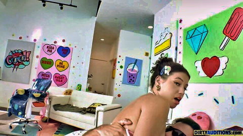 Topless brunette woman teasing on couch with man behind her