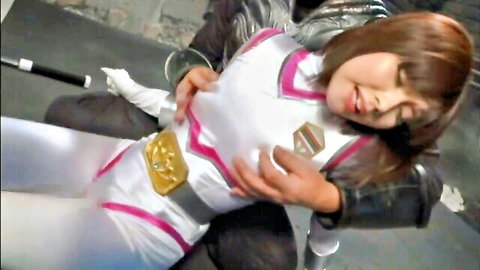 Asian superheroine in shiny white-pink bodysuit bound and groped by man in black