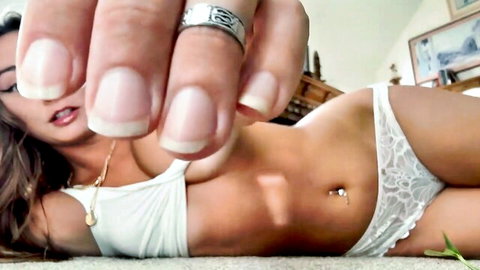 Seductive Latina in sheer white lace bra and thong teases with manicured hand and pierced navel
