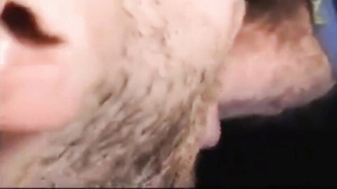 Blurry close-up of bearded man's profile in blue shirt
