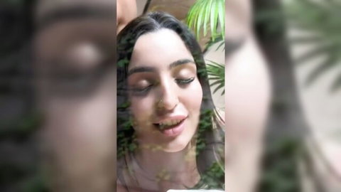 Nefernikk's seductive close-up with green leaf overlay, sensual smile