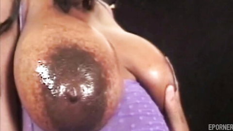 Ebony woman's huge shiny milky breast exposed in purple bra fetish close-up