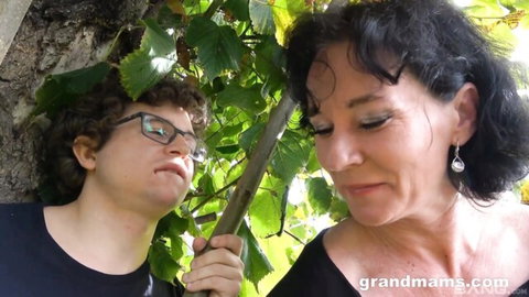Mature brunette Rita Black with young partner in outdoor tease, black tops and glasses