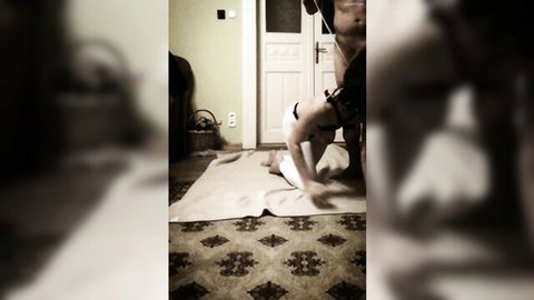 Muscular shirtless dom leashes collared submissive girl on all fours in indoor BDSM pet play