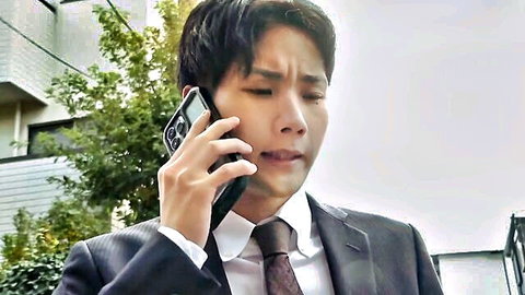 Emotional Asian man in suit on phone, hotel receptionist scene