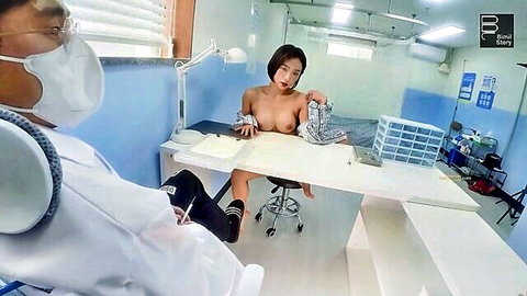 Naked Korean woman with perky tits and shaved pussy exposed on exam table for masked doctor