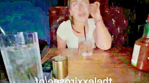Shocked blonde woman in white top at table, reacting with surprise