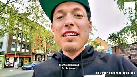 Young man in green cap and black hoodie smiling on street with stevenshame.dating watermark