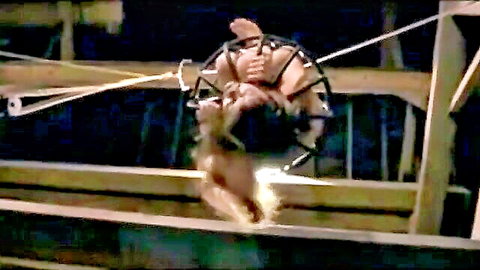 Nude woman suspended in outdoor BDSM bondage training