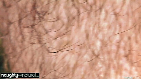 Extreme close-up of hairy pussy with thick dense bush and visible pink labia.