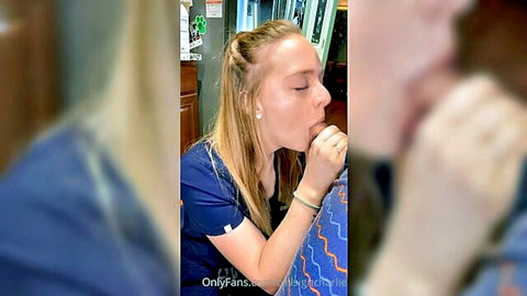 Blonde nurse in scrubs kissing blurred partner passionately