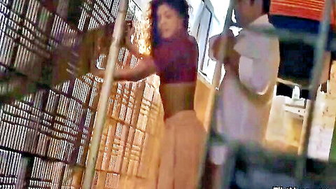 Indian girl in red crop top and pants with boyfriend in warehouse