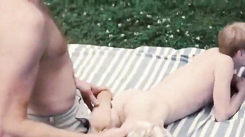 Hairy daddy touching nude twink boy's ass outdoors on blanket
