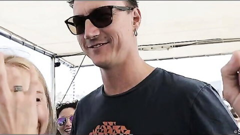 Tanned man and two smiling blondes on Mykonos boat holiday