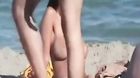 Hot mature woman with enormous boobs posing nude at sunny beach
