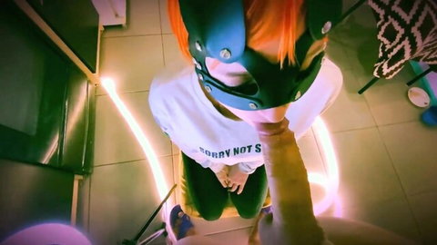 Red-haired girl in green mask giving blowjob in neon lighting, amateur style