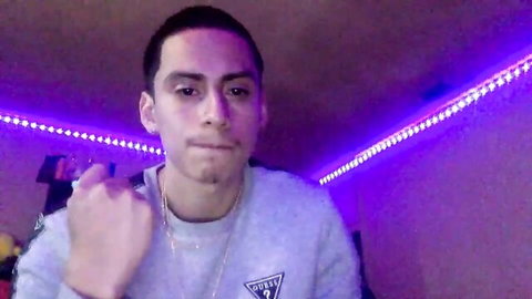 Young Latino guy smoking in gray Guess hoodie, gay hookup vibe