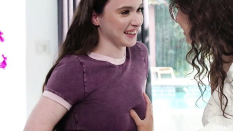 Smiling young brunette in purple shirt chats with curly-haired woman by pool