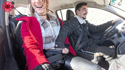Smiling woman in red fur coat flirts with bearded driver in car on public road amateur style