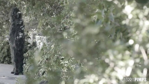 Mature woman peeking through bushes in outdoor Cherry Pimps scene