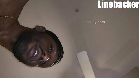 Smiling upside-down Black muscular man in football team gangbang