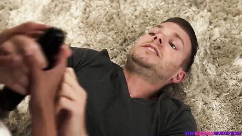 Step-brother lounging on floor with controller before Harley Haze scene