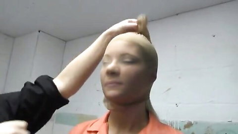Shaved-head prisoner in orange jumpsuit touched during visit