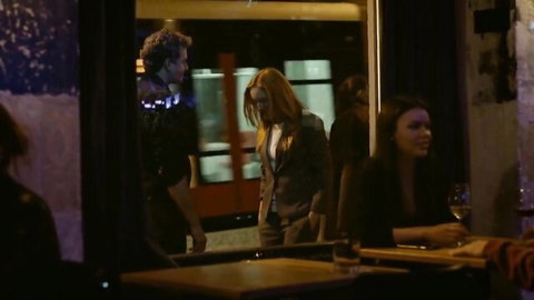 Brunette wives flirt seductively at dimly lit bar while suited redhead and curly-haired husband watch eagerly