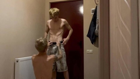 Two shirtless blond twinks in standing anal sex pose