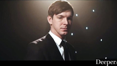 Suited man on stage in Deeper video with Mia Melano