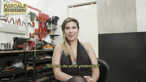 Blonde woman in low-cut black top smiling during garage workshop interview